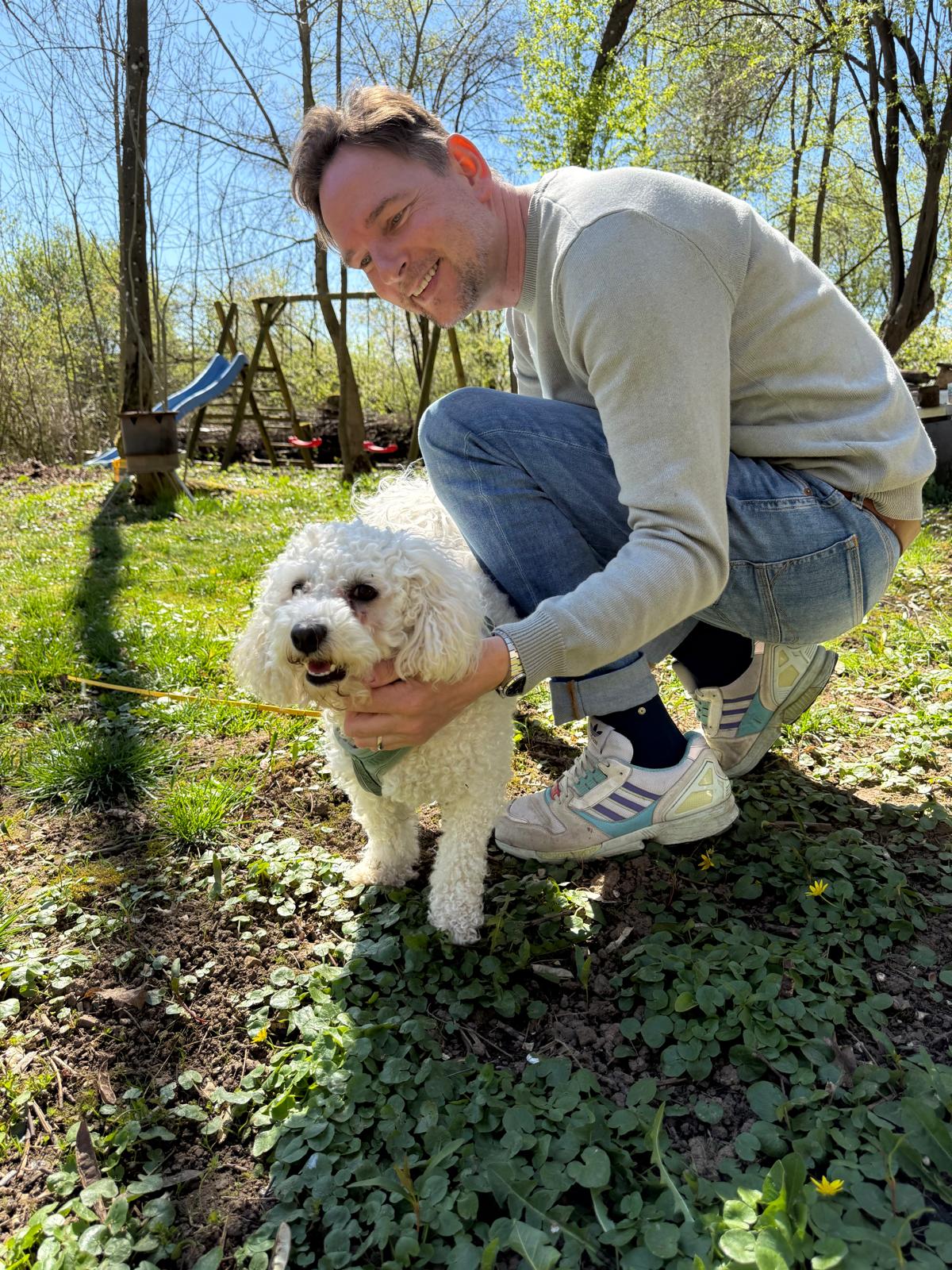 Erik Mattusch-Weiss kniend mit seinem Bichon Frisé